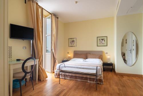 a bedroom with a large bed and a mirror at Hotel De La Plage in Pietra Ligure