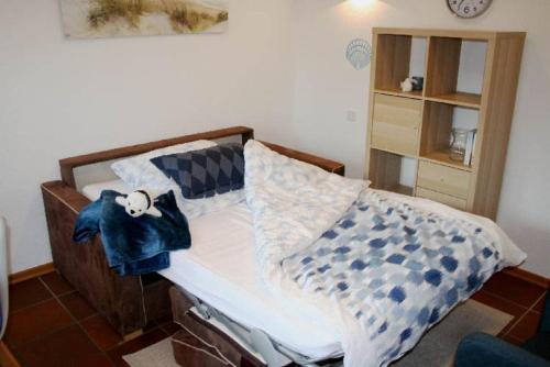 ein Schlafzimmer mit einem Bett mit einer blauen Decke darauf in der Unterkunft Haus Rika 2 in Neuharlingersiel