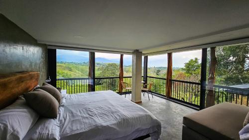 シルカシアにあるCasa Piamonte Quindíoのベッドルーム1室(ベッド1台付)、景色を望むバルコニーが備わります。