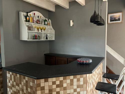 a kitchen with a black counter top and some bottles at Deja Blu in Southbroom