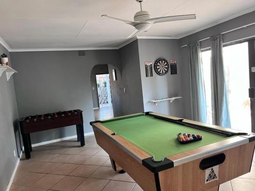 a living room with a pool table and a ceiling fan at Deja Blu in Southbroom