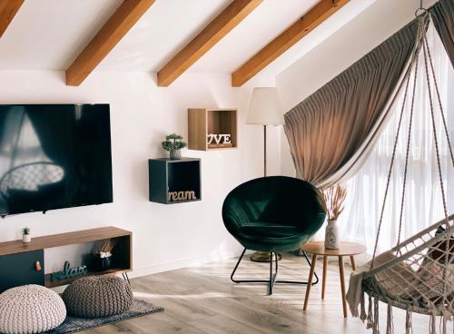 a living room with a green chair and a tv at QUEEN’S HEART GUESTHOUSE in Bran