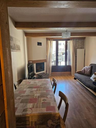 un salon avec une table et un canapé dans l'établissement Appartement 2 pièces au milieu des chalets. Grande Terrasse Orientée Sud, à Saint-Étienne-de-Tinée
