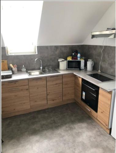 une cuisine avec un évier et un micro-ondes dans l'établissement Le Portel authentique, hypercentre, à Le Portel