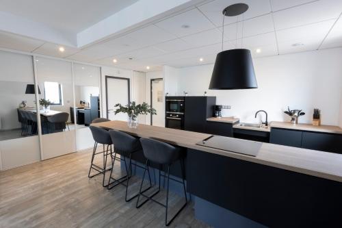 a kitchen with a large island with bar stools at Les Terrasses du Port in Saint-Pierre