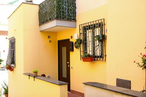 un edificio giallo con balcone con piante di Naboo Guest House - Amalfi Coast a Salerno