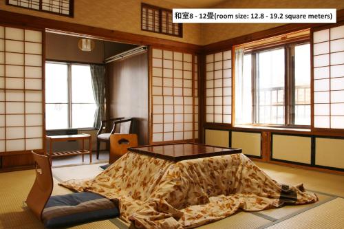 um quarto com uma cama num quarto com janelas em Takasagoya Ryokan em Zao Onsen