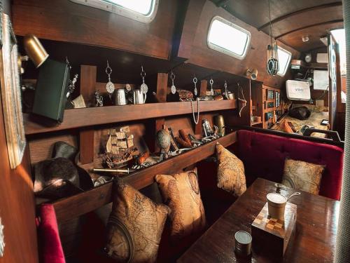 Habitación con sofá y mesa con almohadas. en The Captains Locker - 30ft Yacht, en San Miguel de Abona