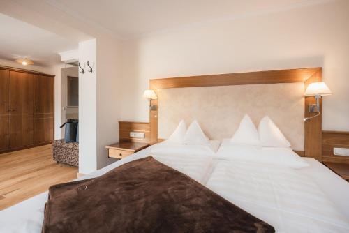 a bedroom with a large white bed with white pillows at Alpine Resort Goies Superior in Ladis