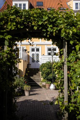 un arco frente a una casa con puerta en Arnfeldt Hotel & Restaurant, en Ærøskøbing