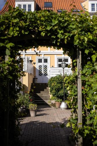 um arco em frente a uma casa com uma porta em Arnfeldt Hotel & Restaurant em Ærøskøbing