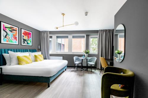 um quarto de hotel com uma cama, uma mesa e cadeiras em numa l Saga Apartments em Bremen