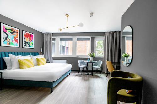 a hotel room with a bed and a table and chairs at numa l Saga Apartments in Bremen