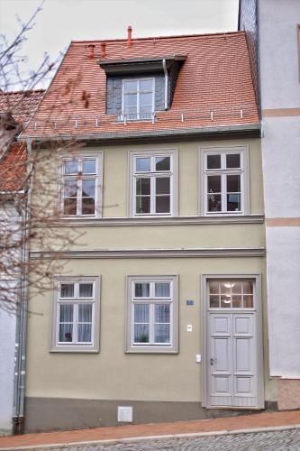 żółty dom z białymi drzwiami i oknami w obiekcie Pößnecker Werkstätten - FeWo Katharina von Bora w mieście Pößneck