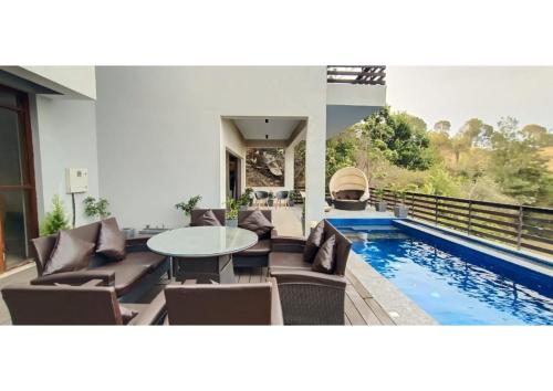 une terrasse avec une table et des chaises ainsi qu'une piscine dans l'établissement villa 7, à Patta