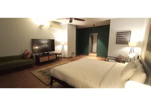a bedroom with a bed and a flat screen tv at villa 7 in Patta