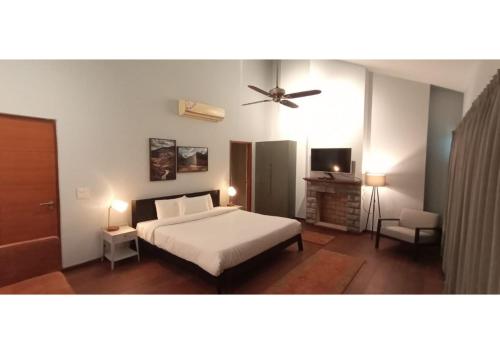 - une chambre avec un lit et un ventilateur de plafond dans l'établissement villa 7, à Patta