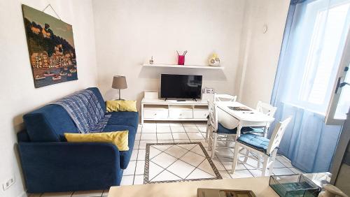 un salon avec un canapé bleu et une télévision dans l'établissement Casa vacanze Casa Elena, à San Giorgio a Cremano