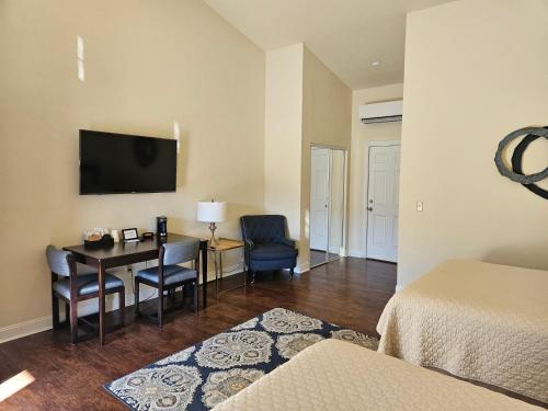 um quarto de hotel com uma secretária e uma televisão na parede em Sunset Cottage Motel Rooms em Ligonier