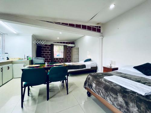 Un dormitorio con dos camas y una mesa y sillas. en Hospedaje Santaisa, en Cali