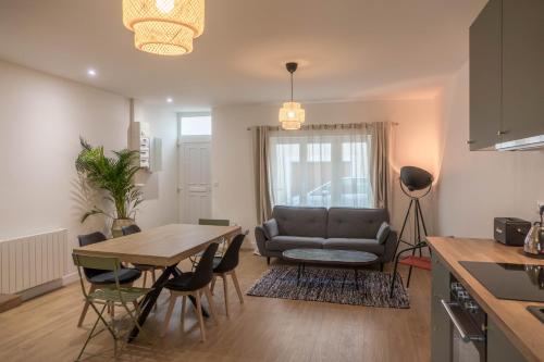 une cuisine et un salon avec une table et un canapé dans l'établissement Beau quartier et central, maison spacieuse avec cour, 3 chambres, 3 salles de bains à 10 min à pied de la gare, à Orléans