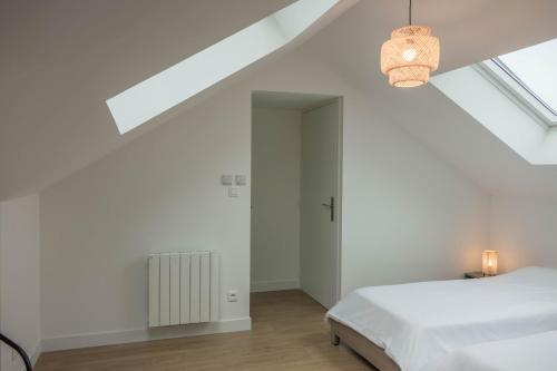 ein weißes Schlafzimmer mit einem Bett und einem Fenster in der Unterkunft Maison rénovée-moderne avec cour à 2 pas du centre in Orléans