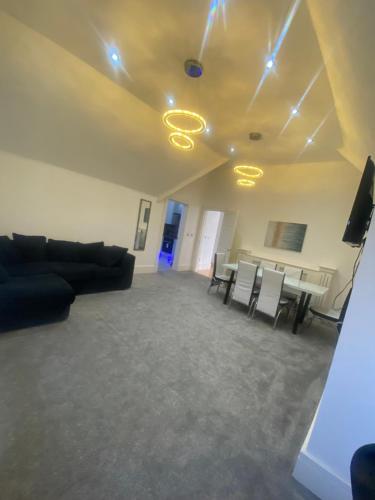 een woonkamer met een bank en een tafel en stoelen bij Penthouse APT8 in Wolverhampton