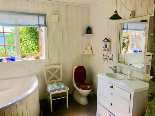 La salle de bains est pourvue de toilettes, d'un lavabo et d'une baignoire. dans l'établissement House by the Sea, à Sortland