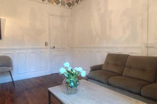 - un salon avec un canapé et une table ornée de fleurs bleues dans l'établissement Appartement de charme avec jardin, à Puteaux