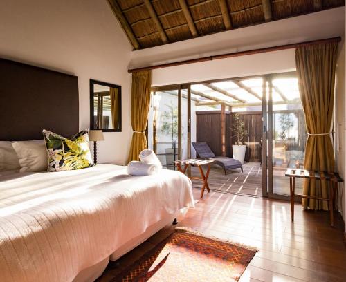 a bedroom with a large bed and a patio at St Francis Golf Lodge in St Francis Bay