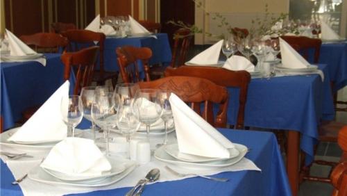 una mesa con mesas azules con copas de vino y servilletas en Hotel Splendid en Eforie Sud