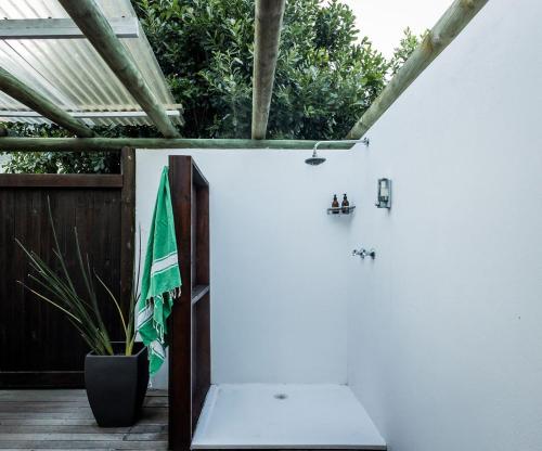 a room with a white wall and a green umbrella at St Francis Golf Lodge in St Francis Bay