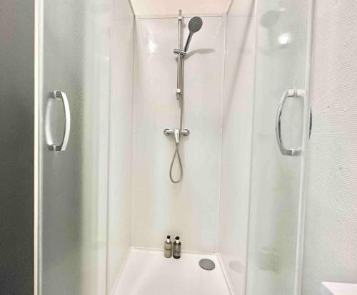 La salle de bains est pourvue d'une douche et d'un lavabo blanc. dans l'établissement Ipanema, au Centre ville de Lens, à Lens