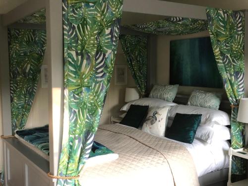 a bedroom with two beds with green curtains at The Nest Danehill in Haywards Heath