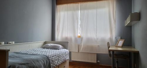 a small bedroom with a bed and a window at Apartamento en Coruña con parking in A Coruña