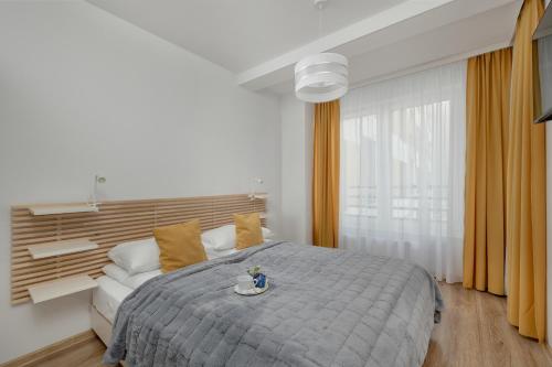 a bedroom with a large bed and a couch at Exclusive and Modern Grey Apartment with Furnished Balcony in Kołobrzeg by Noclegi Renters in Kołobrzeg
