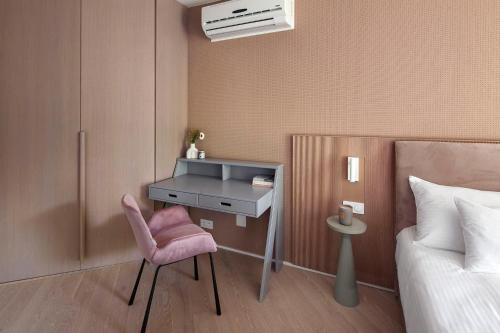 a bedroom with a desk and a pink chair at Apartamenty na Półwyspie Wydma&Las in Jastarnia