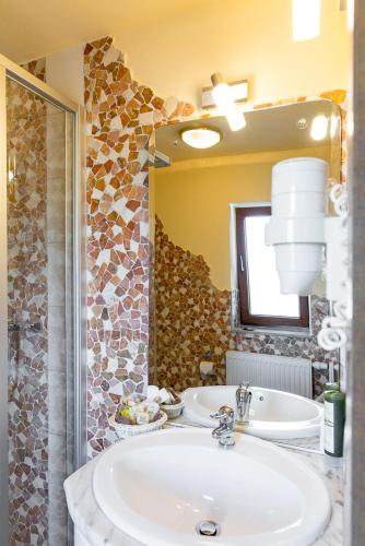 a bathroom with a sink and a mirror at Kräuterhotel Garni Zur Klostergrotte in Nohra