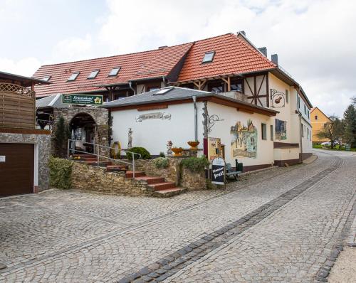 a building on the side of a cobblestone street at Kräuterhotel Garni Zur Klostergrotte in Nohra