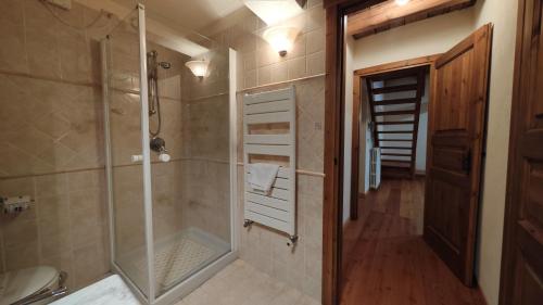 y baño con ducha a ras de suelo y cabina de ducha acristalada. en Hostdomus -Flower Loft en Cesana Torinese