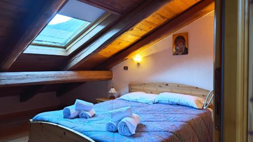 una camera con due letti in mansarda di Hostdomus -Flower Loft a Cesana Torinese