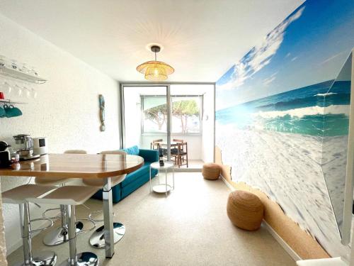 une salle à manger avec une fresque de plage sur le mur dans l'établissement PGH N28 - À 200m de la Plage avec Parking Privé, à La Grande Motte