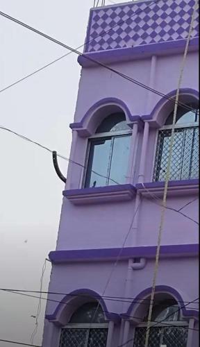 um edifício roxo com uma janela em Maa Mansha guest house em Deoghar