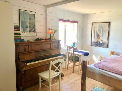 House by the Sea في سورتلاند: غرفة نوم فيها بيانو وطاولة وسرير
