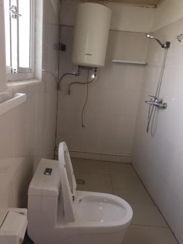 a white bathroom with a toilet and a sink at Alink chinese and korean restaurent in Kigali