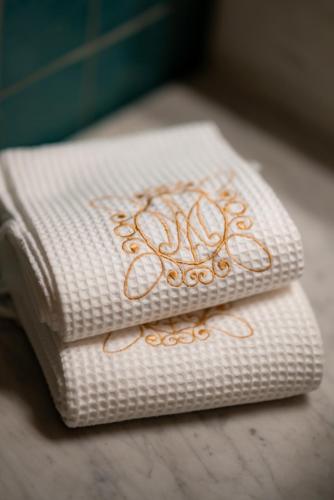 two white towels with orange designs on them at Domaine de Montclair in Pommiers