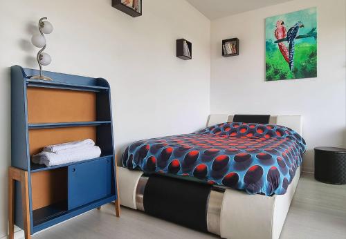 sypialnia z łóżkiem i stolikiem nocnym obok w obiekcie L'Artiste w mieście Soisy-sous-Montmorency