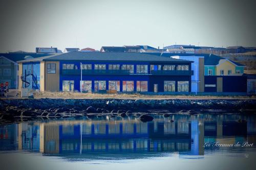 a blue building next to a body of water at Les Terrasses du Port in Saint-Pierre