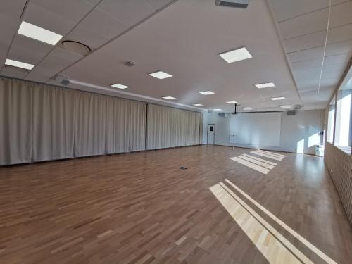 a large room with a wooden floor and curtains at Les Terrasses du Port in Saint-Pierre