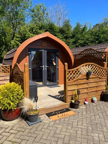 a wooden deck with potted plants in front of a building at Conifer Cabins in Fort William